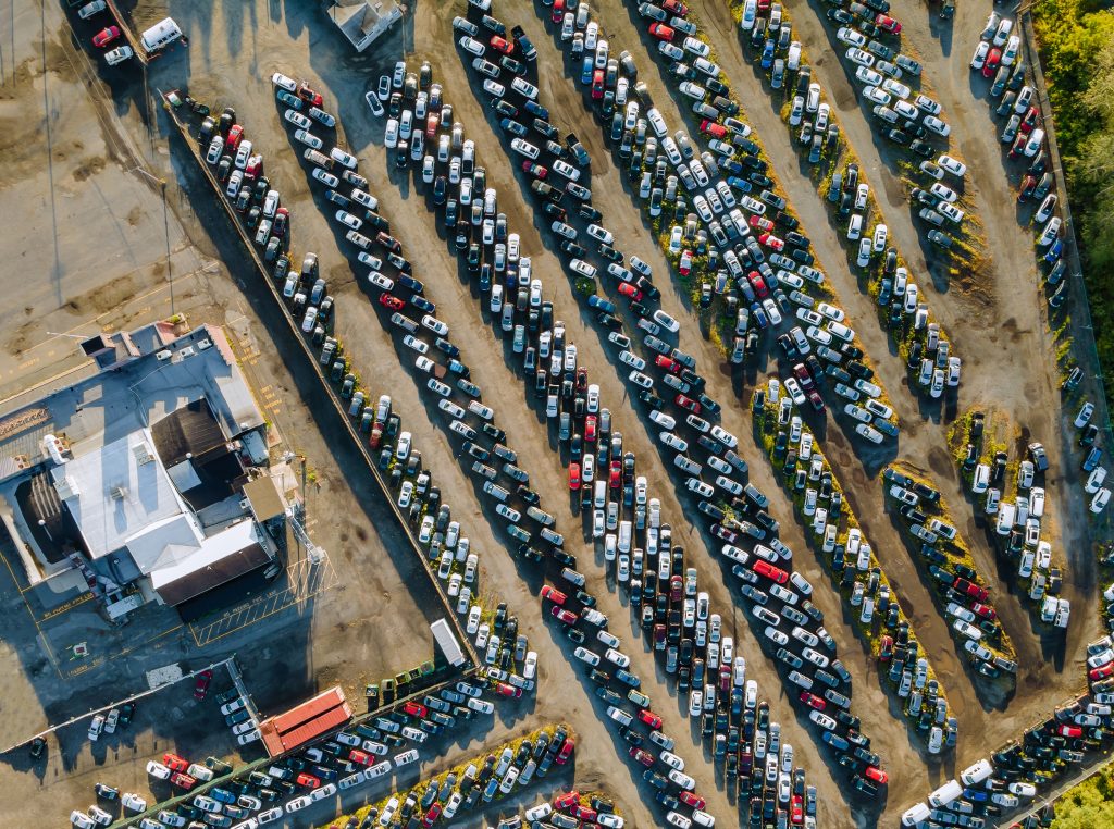 aerial view of auto auction many used car lot parked distributed in a parking.