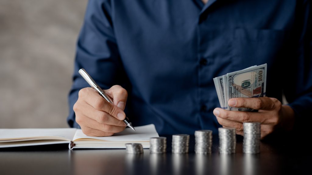 a man counting her salary to separate expenses, he keeps a month