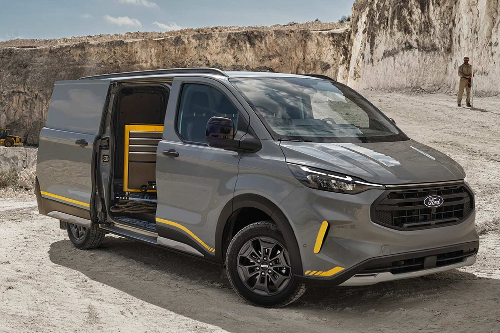 Grijze Ford Transit Custom met open schuifdeur op bouwlocatie