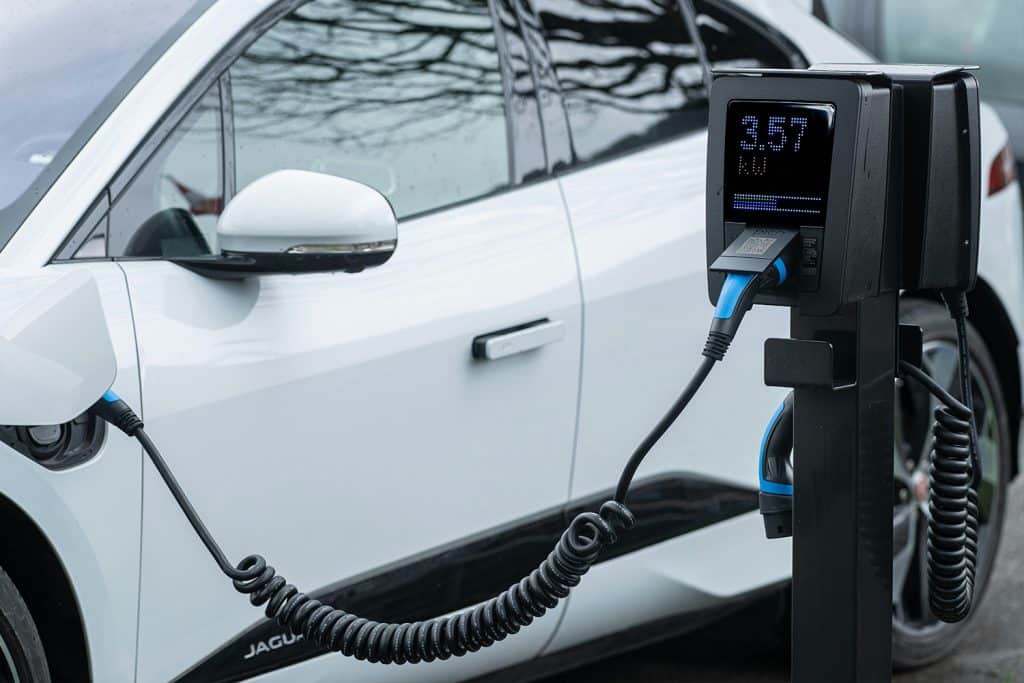 Elektrische auto opgeladen bij openbare laadpaal met digitaal display voor zakelijk gebruik.